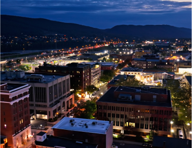 Cityscape at night with illuminated buildings.