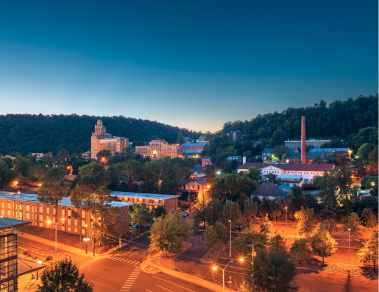 Cityscape with illuminated buildings at dusk.